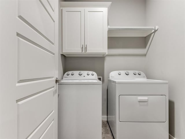 laundry room featuring cabinets, washing machine and dryer, and tile patterned floors