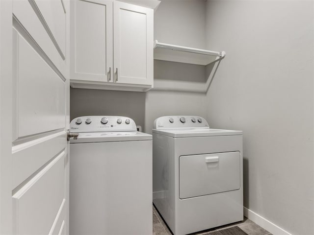 laundry area with washing machine and dryer and cabinets