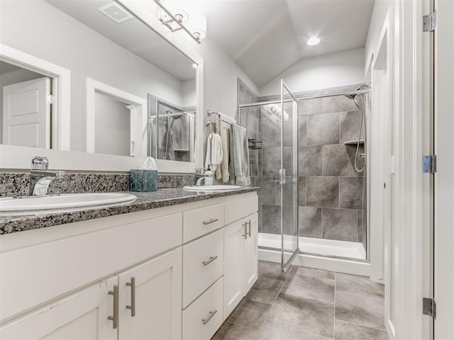 bathroom featuring lofted ceiling, a shower with door, and vanity