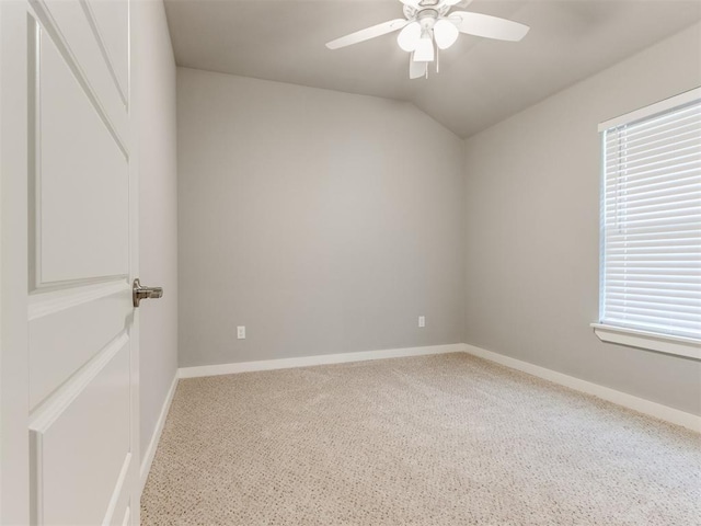 carpeted spare room with ceiling fan and vaulted ceiling