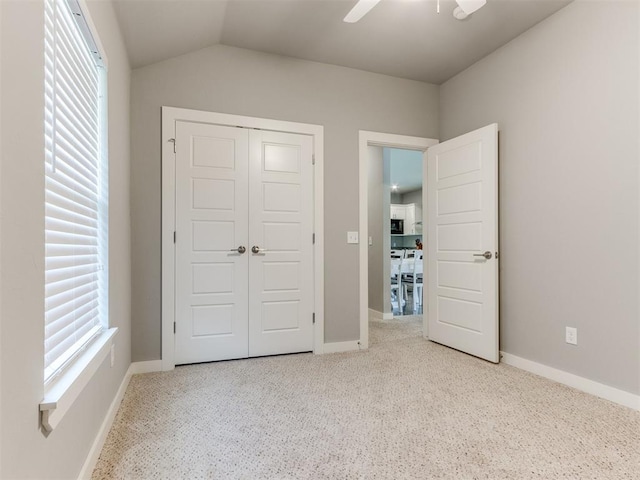 unfurnished bedroom with a closet, ceiling fan, and vaulted ceiling