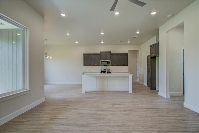 207 Hope Ave, Shawnee, OK 74804 - kitchen with appliances with stainless steel finishes, ceiling fan, open floor plan, light countertops, and light wood finished floors