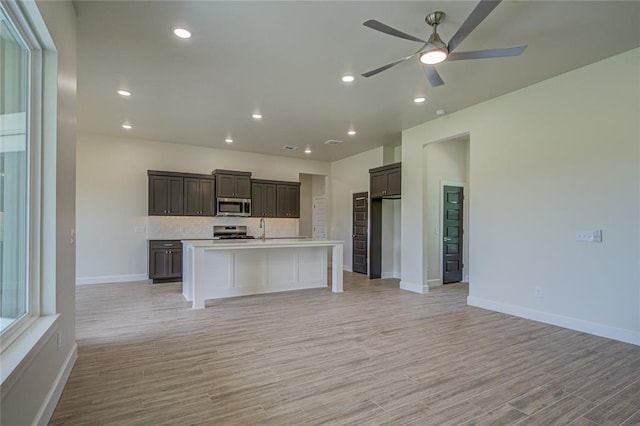 207 Hope Ave, Shawnee, OK 74804 - kitchen featuring stainless steel appliances, open floor plan, a ceiling fan, light countertops, and light wood-style flooring