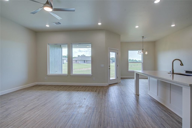 207 Hope Ave, Shawnee, OK 74804 - unfurnished living room featuring wood finished floors, recessed lighting, ceiling fan, and a chandelier