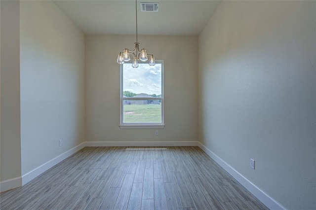 207 Hope Ave, Shawnee, OK 74804 - empty room with a chandelier and wood finished floors
