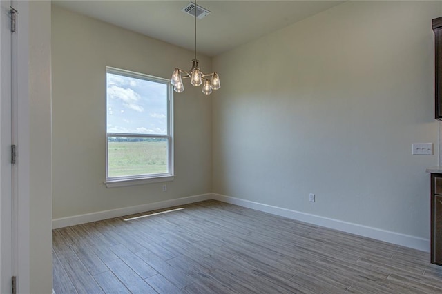207 Hope Ave, Shawnee, OK 74804 - empty room featuring plenty of natural light, wood finished floors, and a chandelier