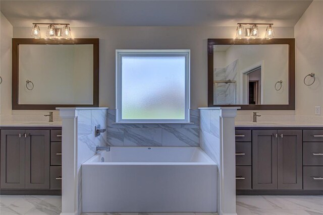 207 Hope Ave, Shawnee, OK 74804 - bathroom featuring marble look tiles, two vanities, and a garden tub