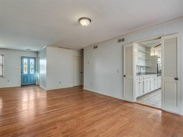 empty room with light hardwood / wood-style floors and sink