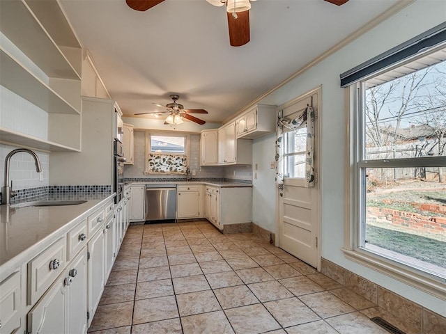 kitchen with stainless steel appliances, white cabinets, decorative backsplash, and sink