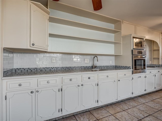 kitchen featuring stainless steel appliances, white cabinets, sink, and tasteful backsplash