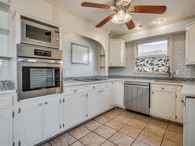 kitchen featuring appliances with stainless steel finishes, tasteful backsplash, white cabinets, and sink