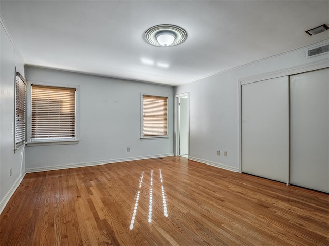 unfurnished bedroom with a closet and hardwood / wood-style floors