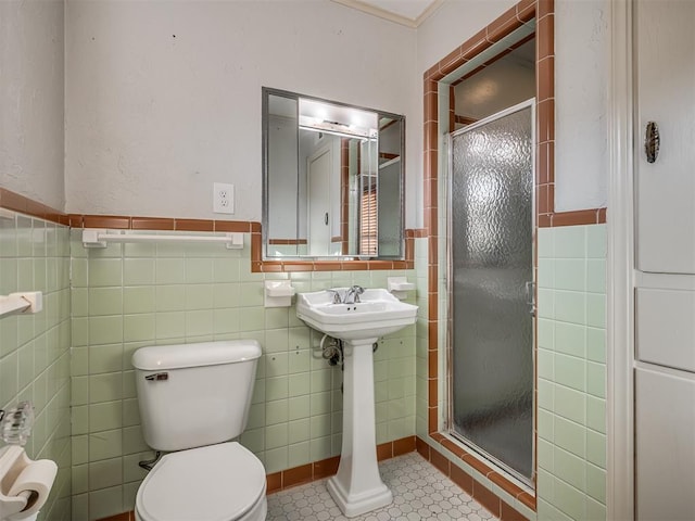 bathroom featuring tile walls, tile patterned floors, a shower with shower door, and toilet