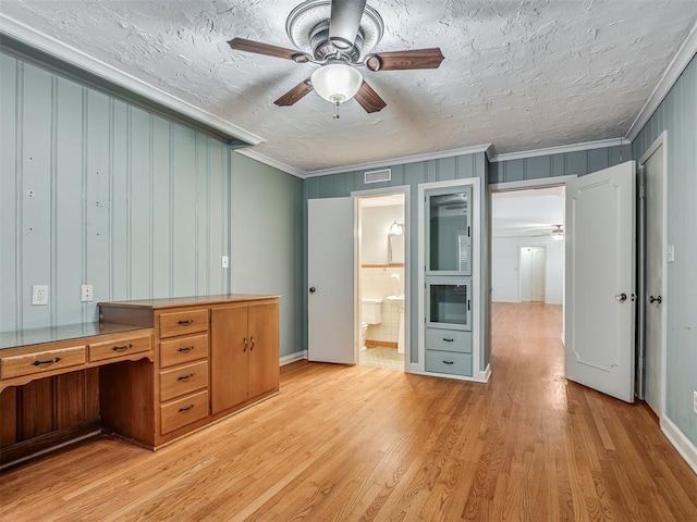 unfurnished office featuring ceiling fan, light hardwood / wood-style flooring, crown molding, and a textured ceiling