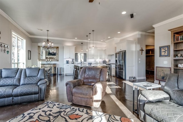 living room with ceiling fan with notable chandelier, crown molding, and sink