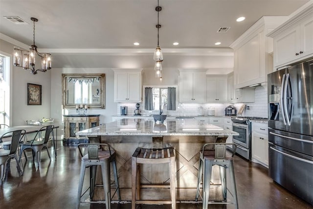 kitchen featuring white cabinets, a center island, hanging light fixtures, and appliances with stainless steel finishes