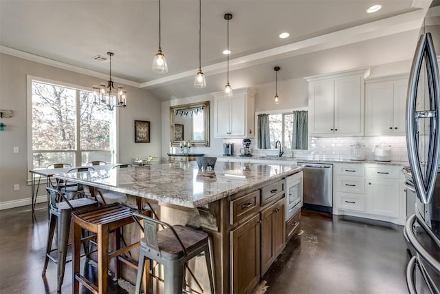 kitchen with dishwasher, refrigerator, decorative light fixtures, a kitchen island, and white cabinetry