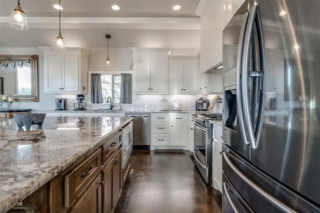 kitchen featuring backsplash, white cabinetry, pendant lighting, and appliances with stainless steel finishes