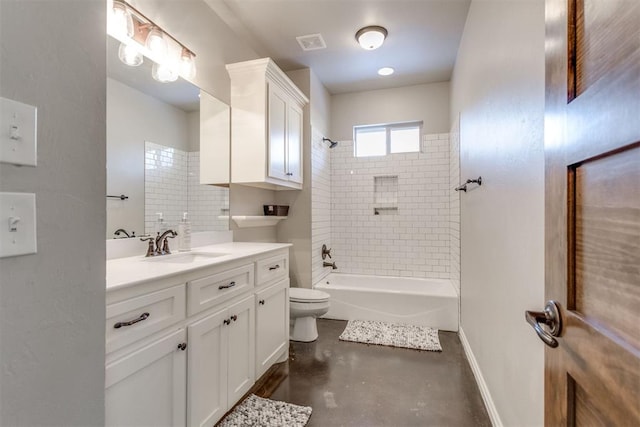 full bathroom featuring concrete floors, tiled shower / bath combo, vanity, and toilet