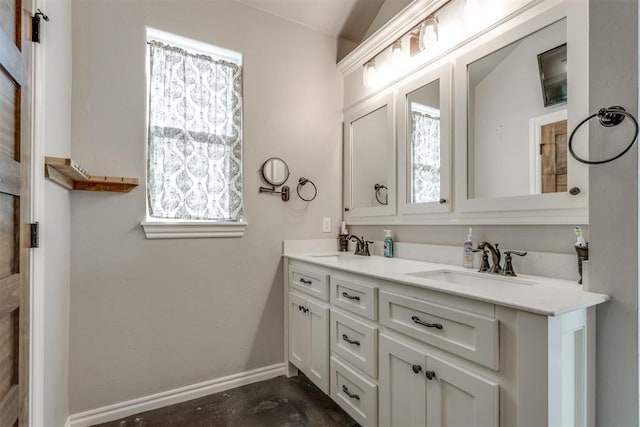 bathroom with lofted ceiling, concrete floors, a wealth of natural light, and vanity