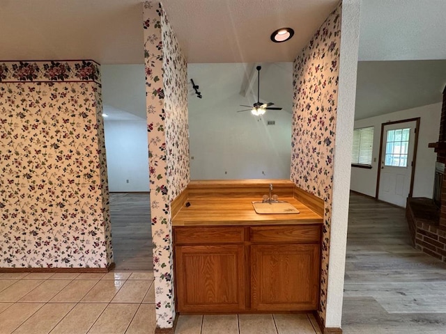 kitchen featuring ceiling fan, light tile patterned floors, and sink