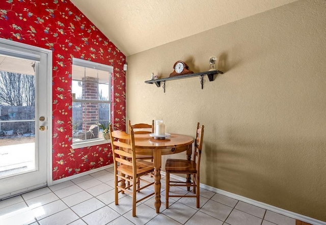 dining space with lofted ceiling and tile patterned floors