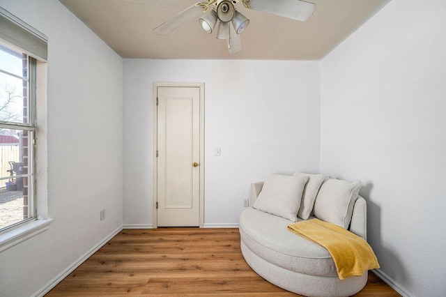 living area featuring ceiling fan and light hardwood / wood-style flooring