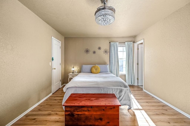 bedroom with a textured ceiling and light hardwood / wood-style flooring