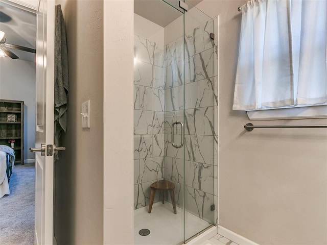 bathroom with ceiling fan and a shower with door