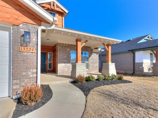 doorway to property featuring a garage and a porch