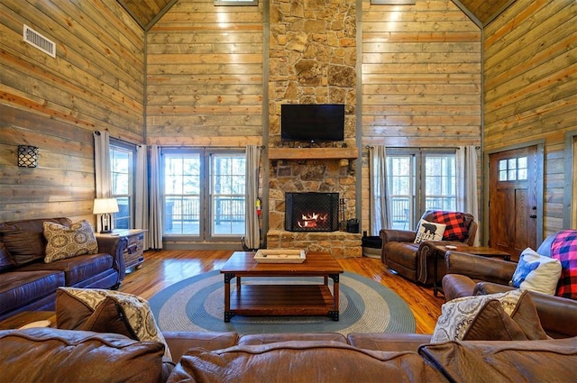 living room featuring high vaulted ceiling, plenty of natural light, a fireplace, and hardwood / wood-style floors