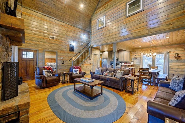 living room with a healthy amount of sunlight, light hardwood / wood-style flooring, and a notable chandelier