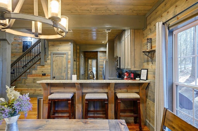 kitchen with wooden ceiling, a healthy amount of sunlight, and appliances with stainless steel finishes