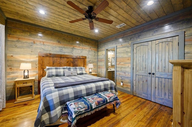 bedroom featuring wood ceiling, wooden walls, ceiling fan, and hardwood / wood-style flooring