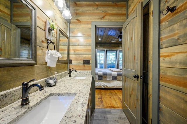 bathroom featuring vanity and wooden walls