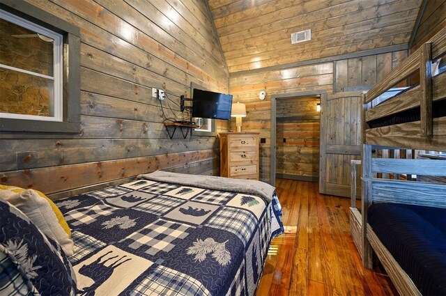 bedroom with dark hardwood / wood-style floors and wood walls