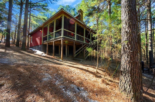 rear view of house featuring a sunroom