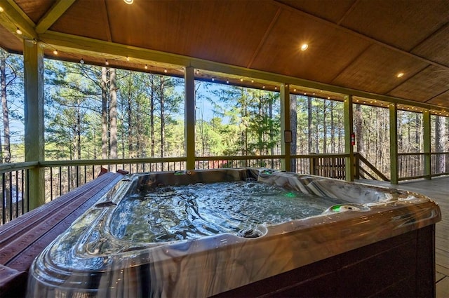 sunroom with a jacuzzi and wooden ceiling