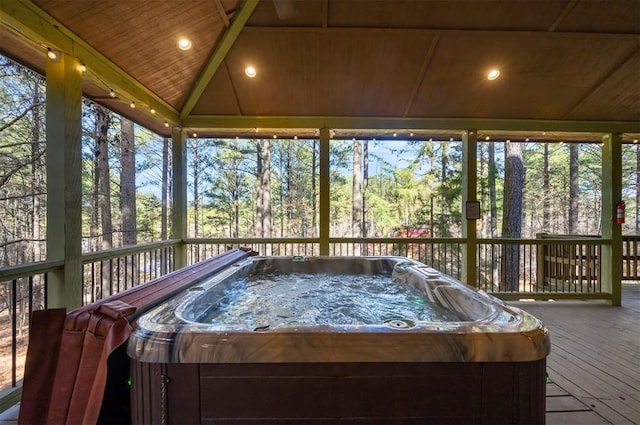 sunroom / solarium with lofted ceiling, a wealth of natural light, a hot tub, and wooden ceiling