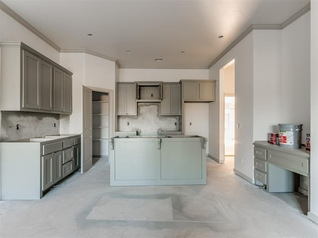 kitchen featuring backsplash, ornamental molding, a center island, and gray cabinetry