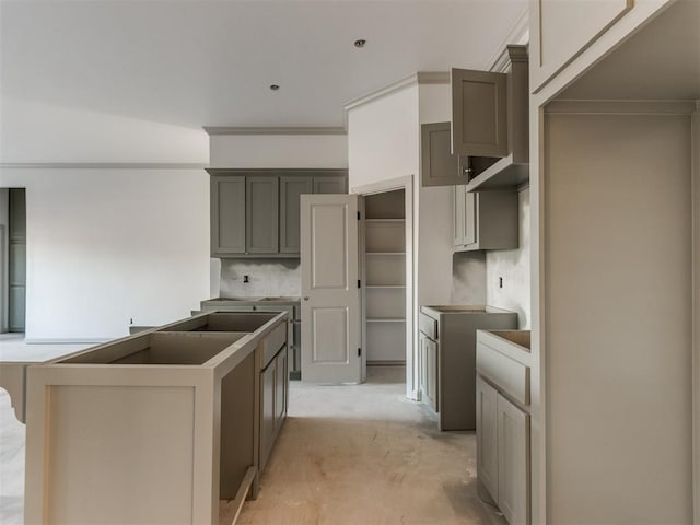 kitchen with crown molding, gray cabinetry, and decorative backsplash