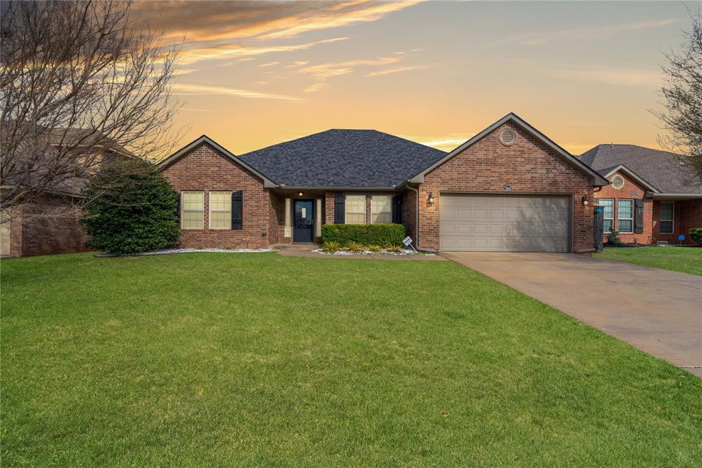 single story home with a lawn and a garage