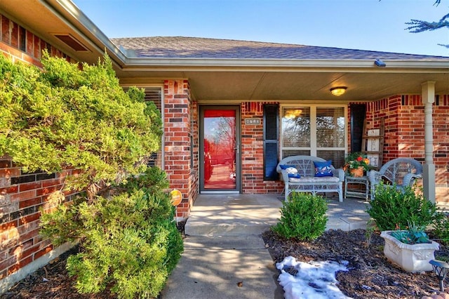 view of exterior entry featuring covered porch