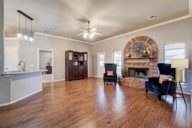 living room with a fireplace, ceiling fan, and crown molding