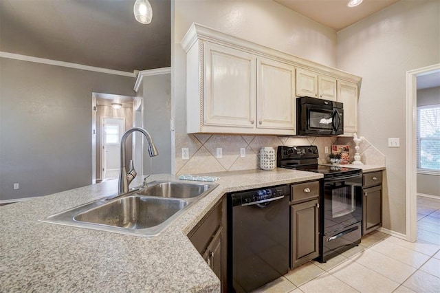 kitchen featuring sink, cream cabinetry, light tile patterned floors, tasteful backsplash, and black appliances