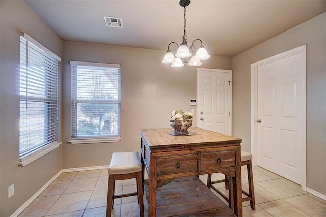 tiled dining area featuring an inviting chandelier