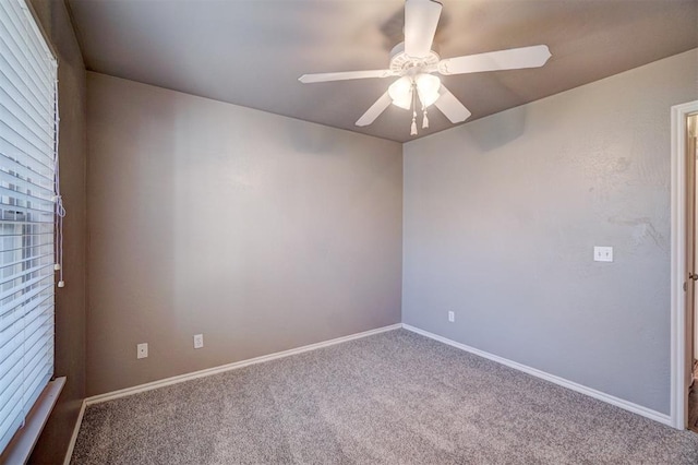 carpeted spare room featuring ceiling fan