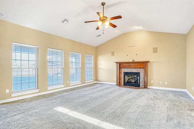 unfurnished living room with vaulted ceiling, ceiling fan, carpet, and a tile fireplace