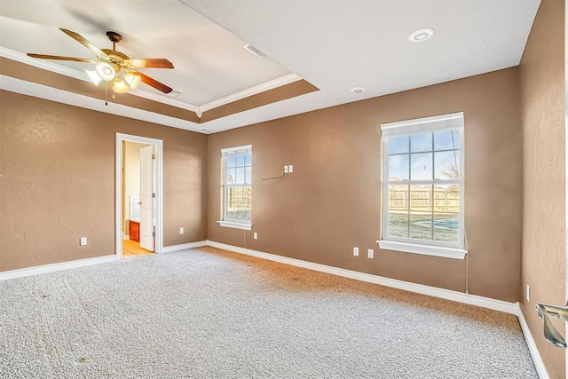 spare room featuring crown molding, light colored carpet, ceiling fan, and a tray ceiling