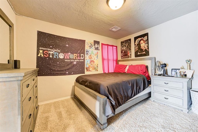 bedroom with a textured ceiling and light carpet